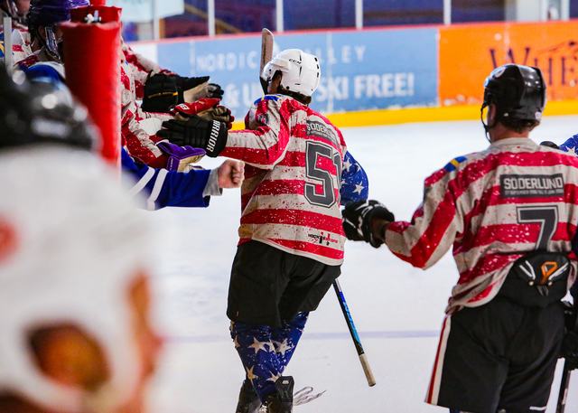 Two USA players in stars-and-stripes jerseys embrace after a goal