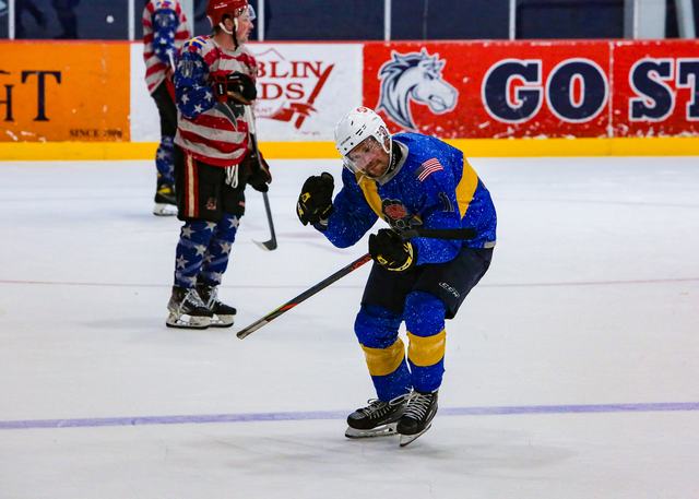 A Sweden forward and a USA defender race for the loose puck