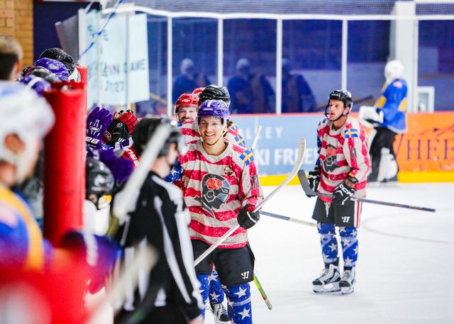 A player in a stars-and-stripes jersey skates past the officials