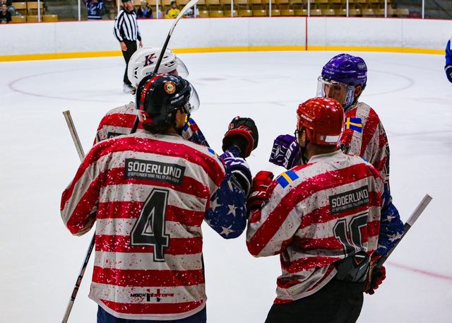 Söderlund-jersey players huddle together during a stoppage in play