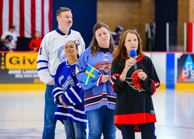 Fans and family members in Sweden and USA jerseys gather rinkside before the game