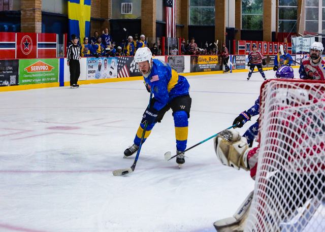 A shot squeezes past the goaltender toward the open net